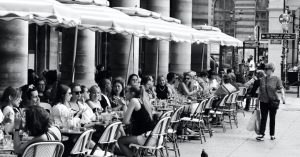 black and white picture of women seated at a café in Paris